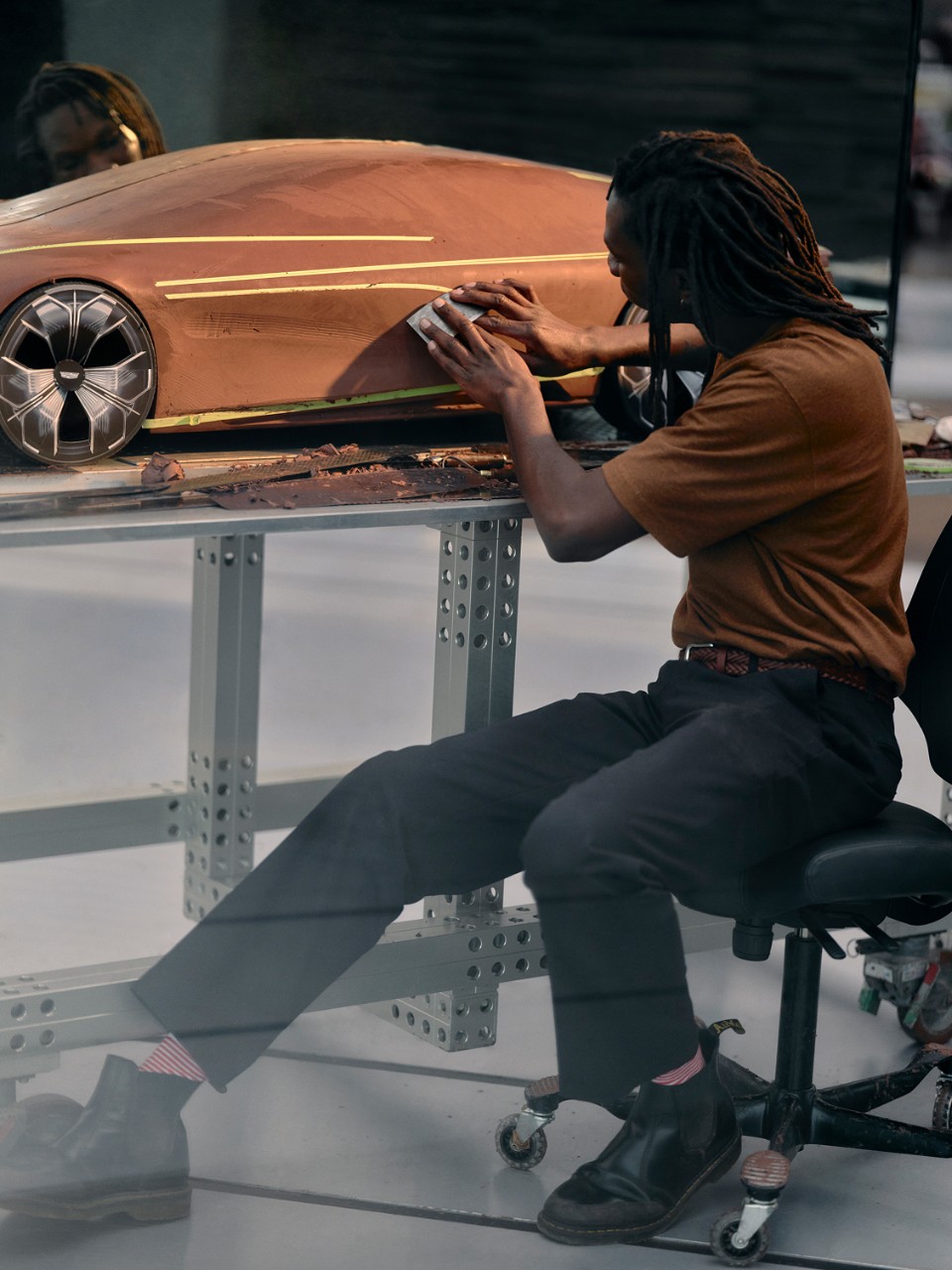 Careers Automotive designer sculpts clay model of a vehicle by hand. refining the vehicle's frame in an automotive design studio.