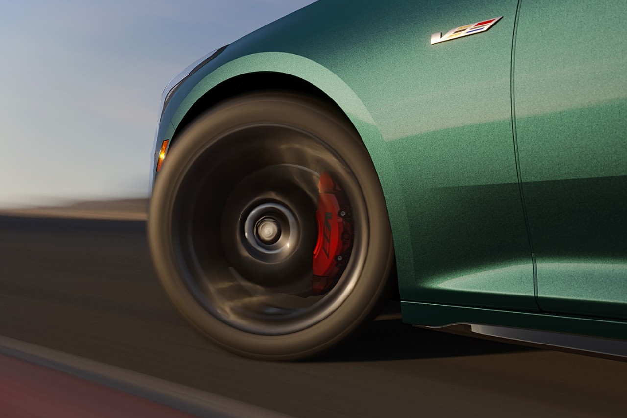 Wheel Close-up of green 2025 Cadillac CT5-V wheel in motion on track, showing red Brembo brake calipers and V-Series badge.