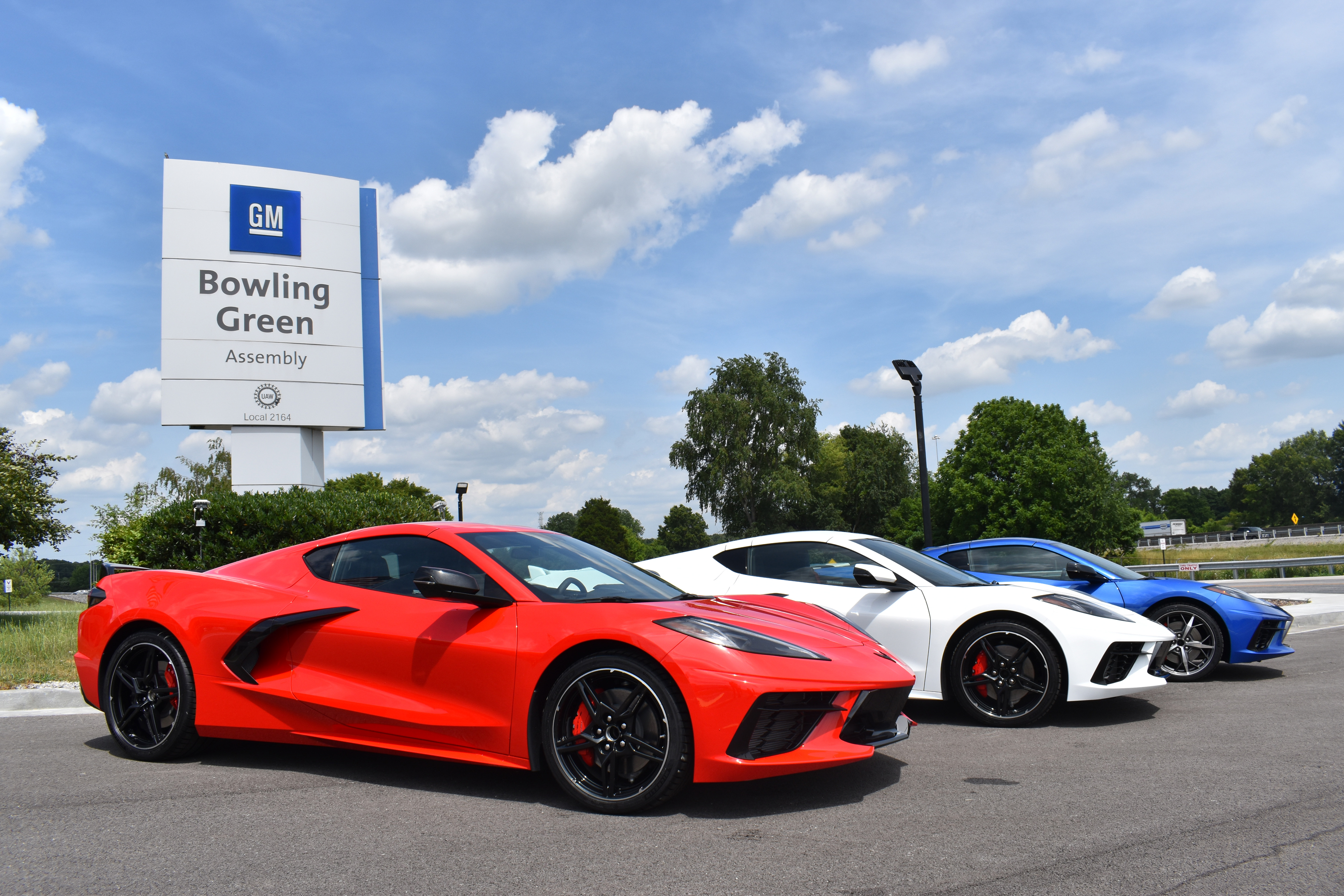Red, white and blue Corvettes in front of Bowling Green sign