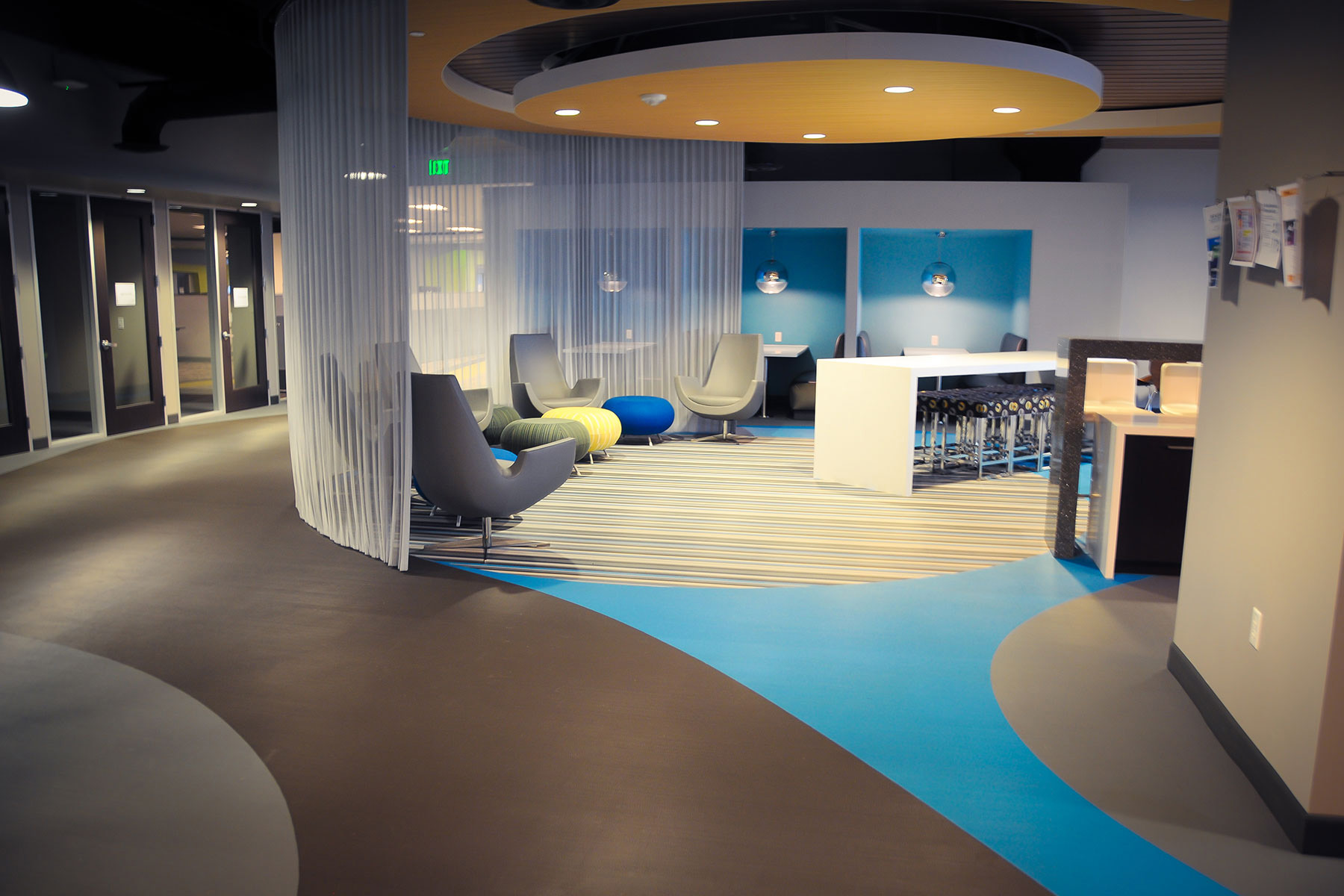 break area with lounge chairs, foot rests, and counter top with chairs at Austin IT Innovation Center