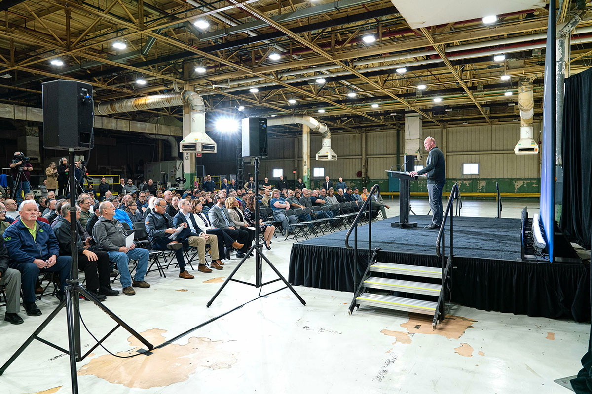 A man addresses and audience at an event for General Motors Bay City GPS.