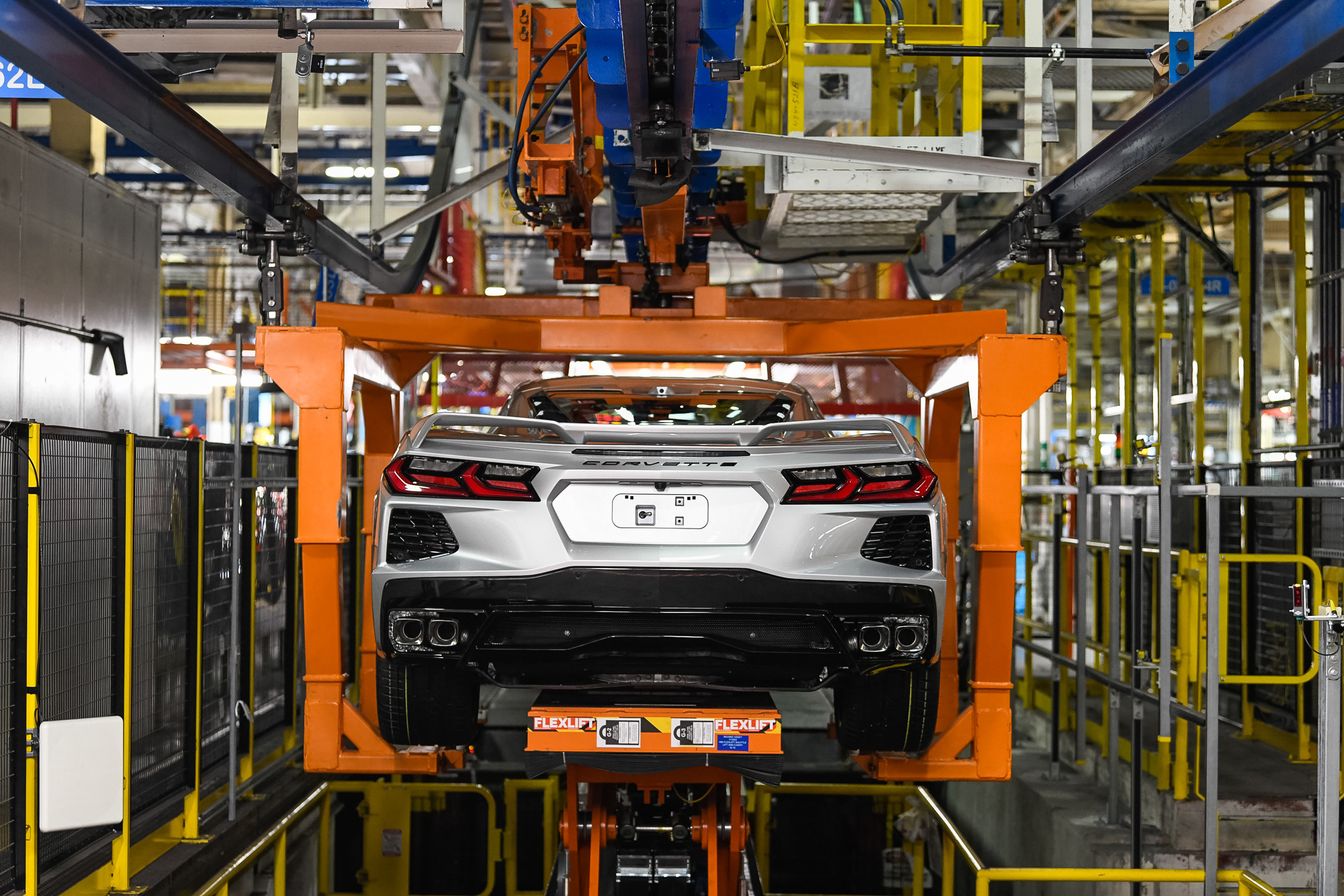 Back side of silver Corvette as lift moves it down assembly line