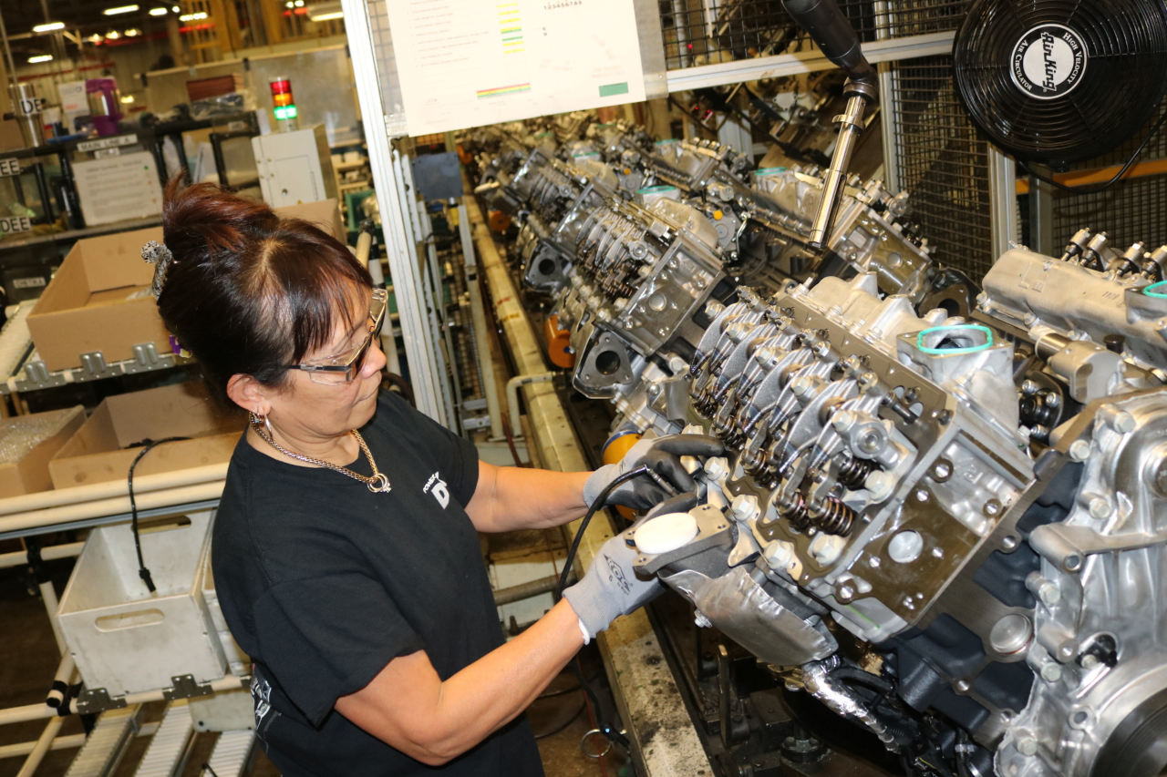 An assembly line worker works on a Duramax diesel engine