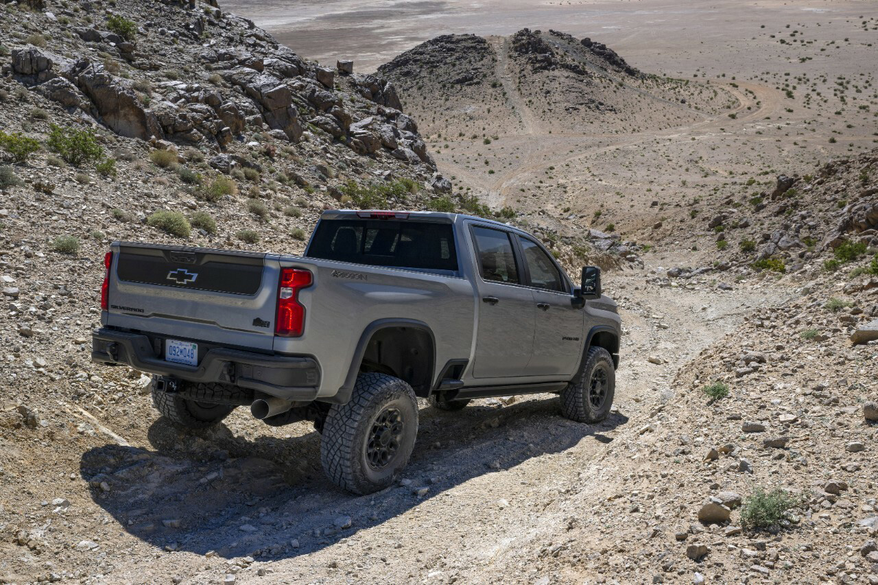 A Chevrolet Silverado HD drives over rocks and hills.