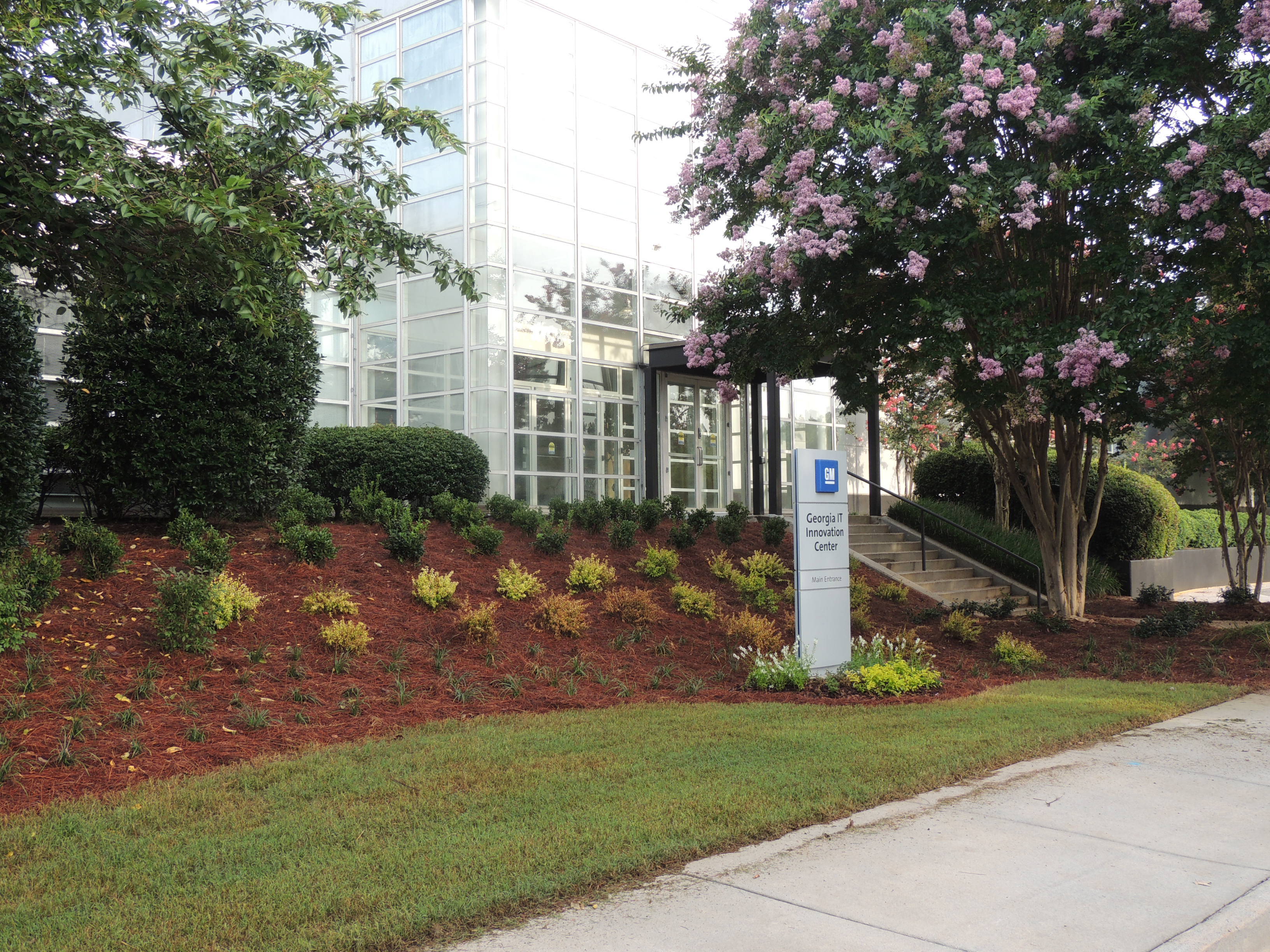 Planter and trees in front of glass GM Georgia IT Innovation Center building