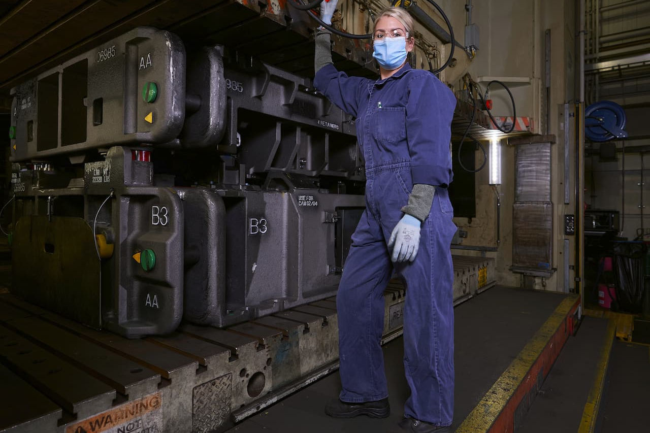 diemaker Sara Olney operates large metal press at NAETC