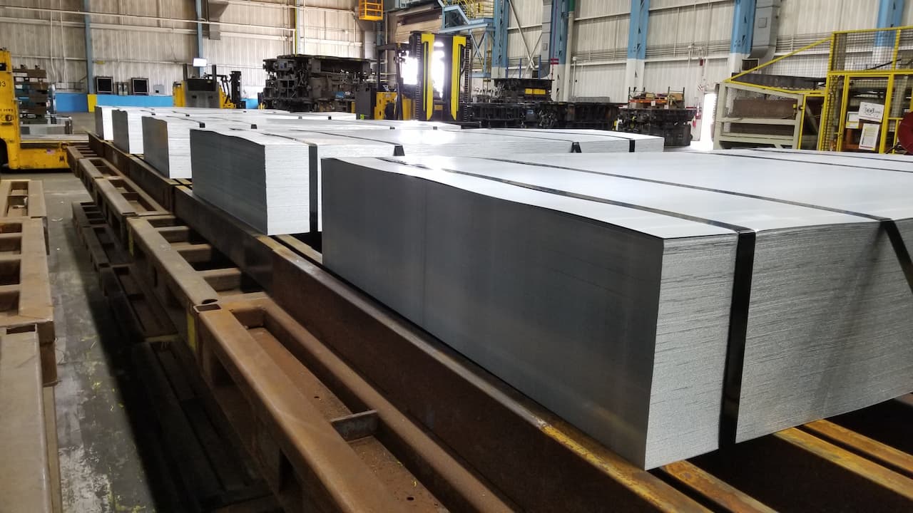 bundles of large metal sheets in line to start production