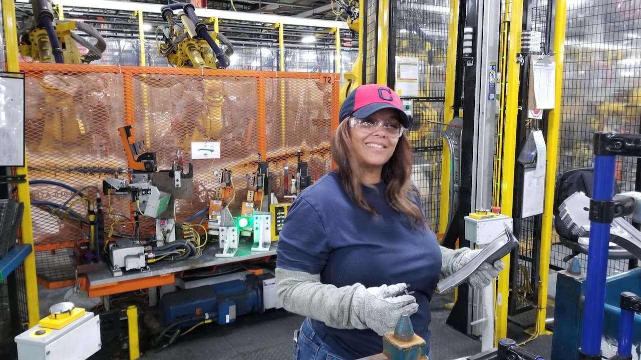 Leslie Stephens does finishing touches on small metal parts utilizing large gloves