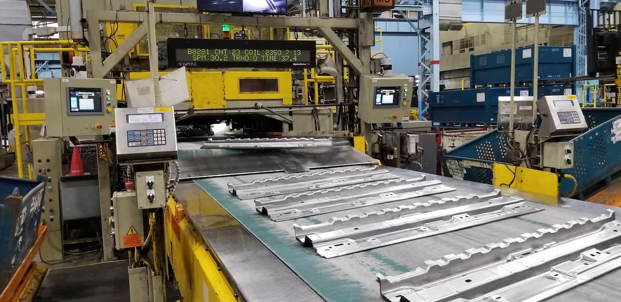 completed stamped metal parts move down the assembly line
