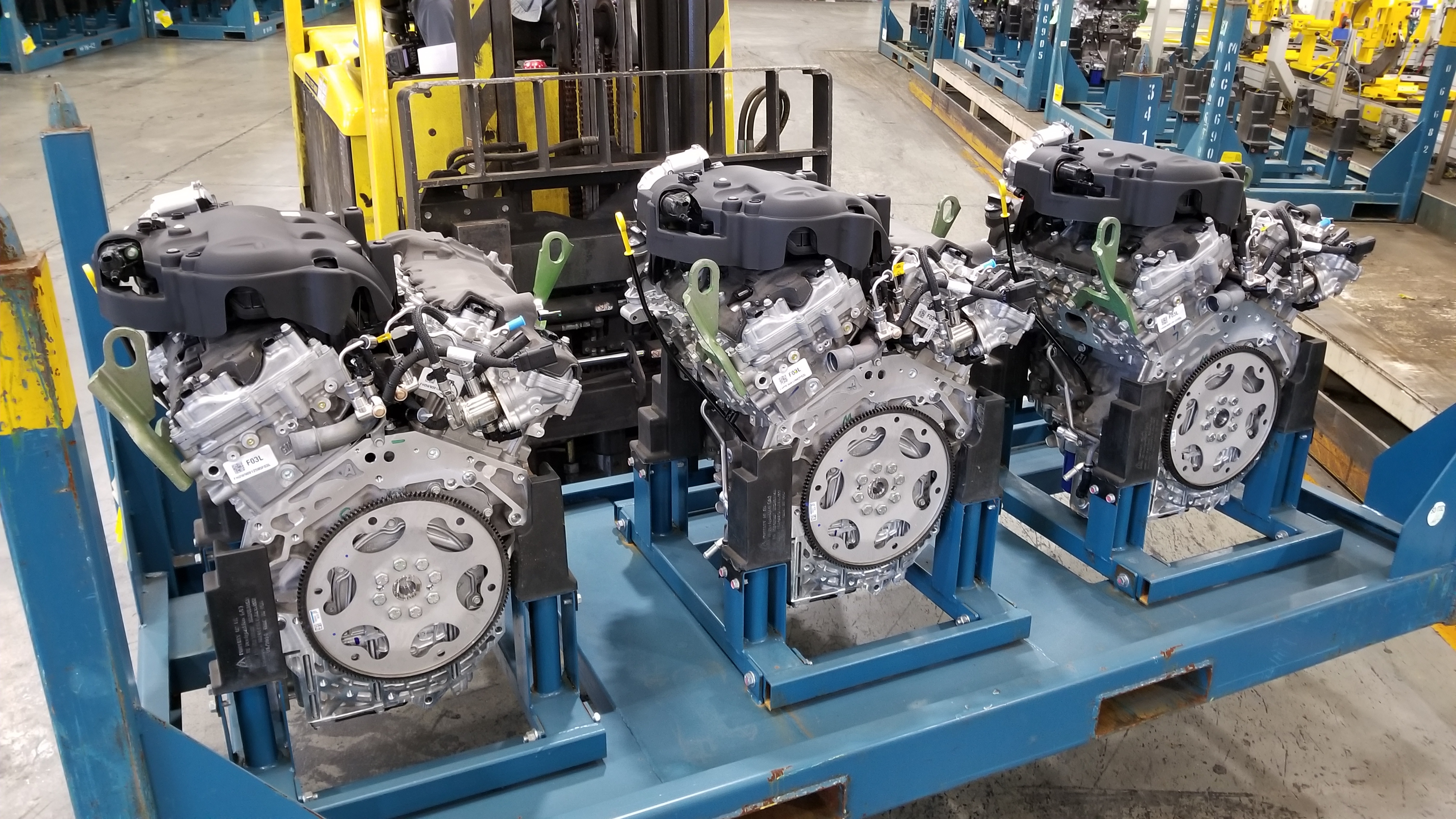 three completed HFV6 engines sit on pallet being moved by forklift