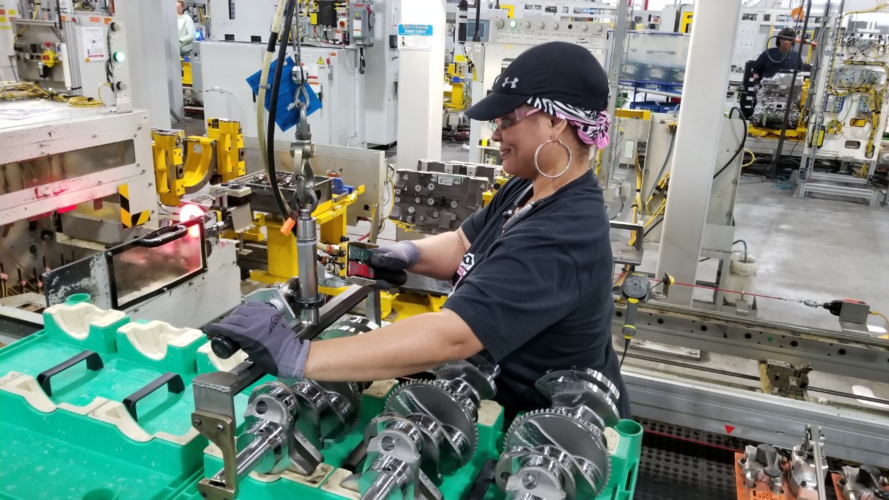Sirena Mapps uses large two handed tool to-work on transmission gearing