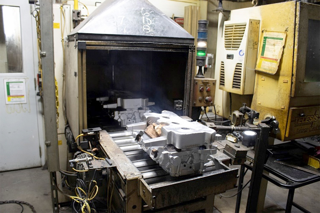 Cylinder head castings cooling after molten aluminum was applied to the solid sand core.