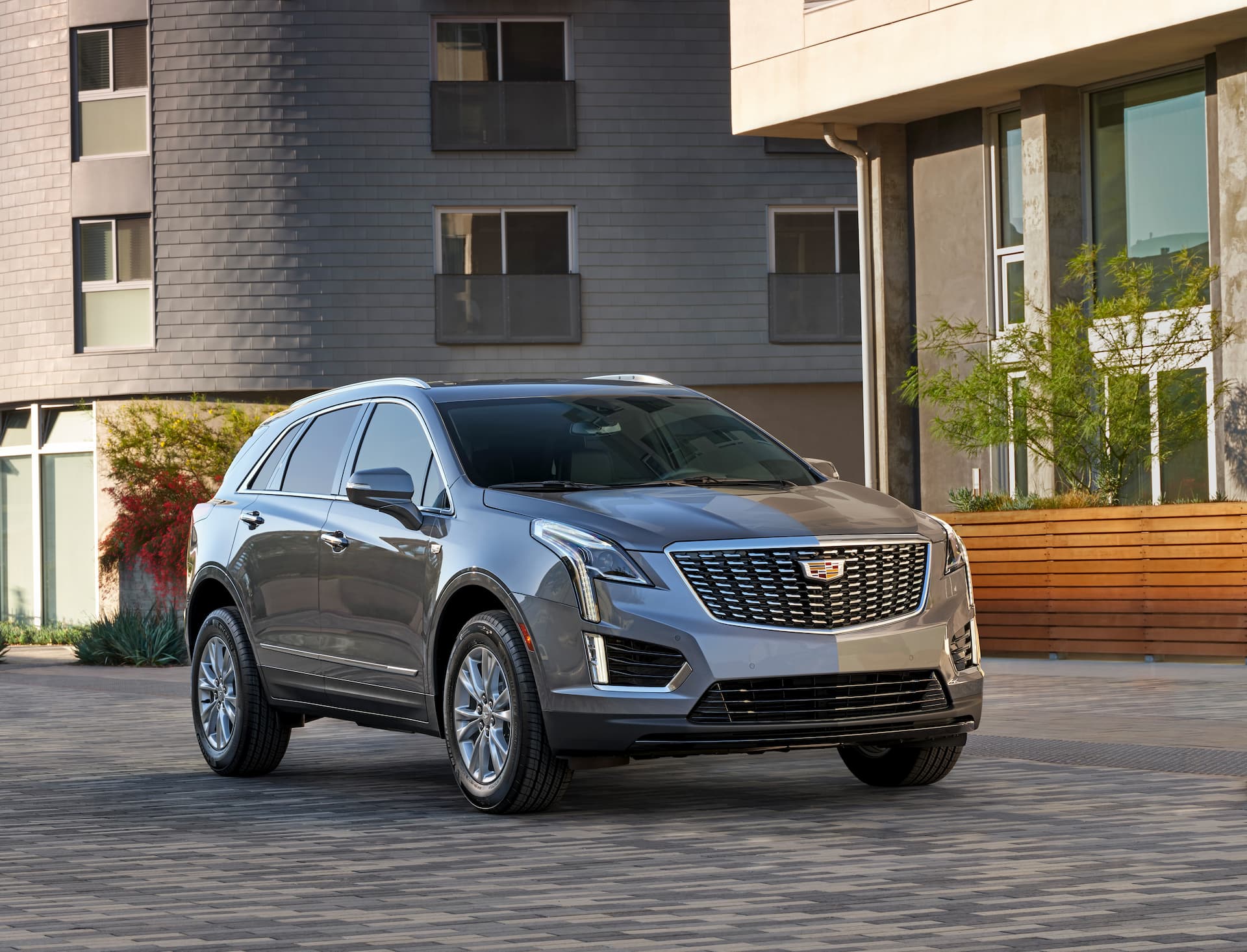 Front / side view of 2021 Cadillac XT5 parked on brick driveway in front of apartment building
