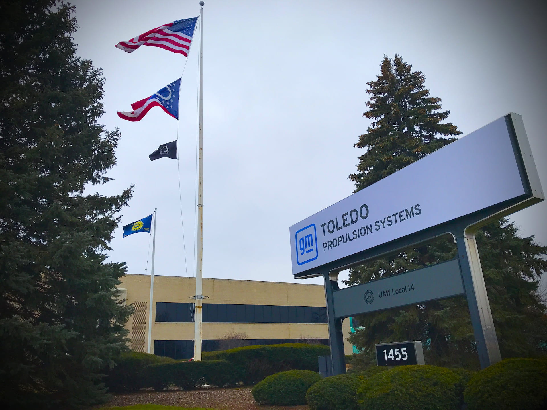 GM Toledo Propulsion Systems exterior building sign with flags flying in the background