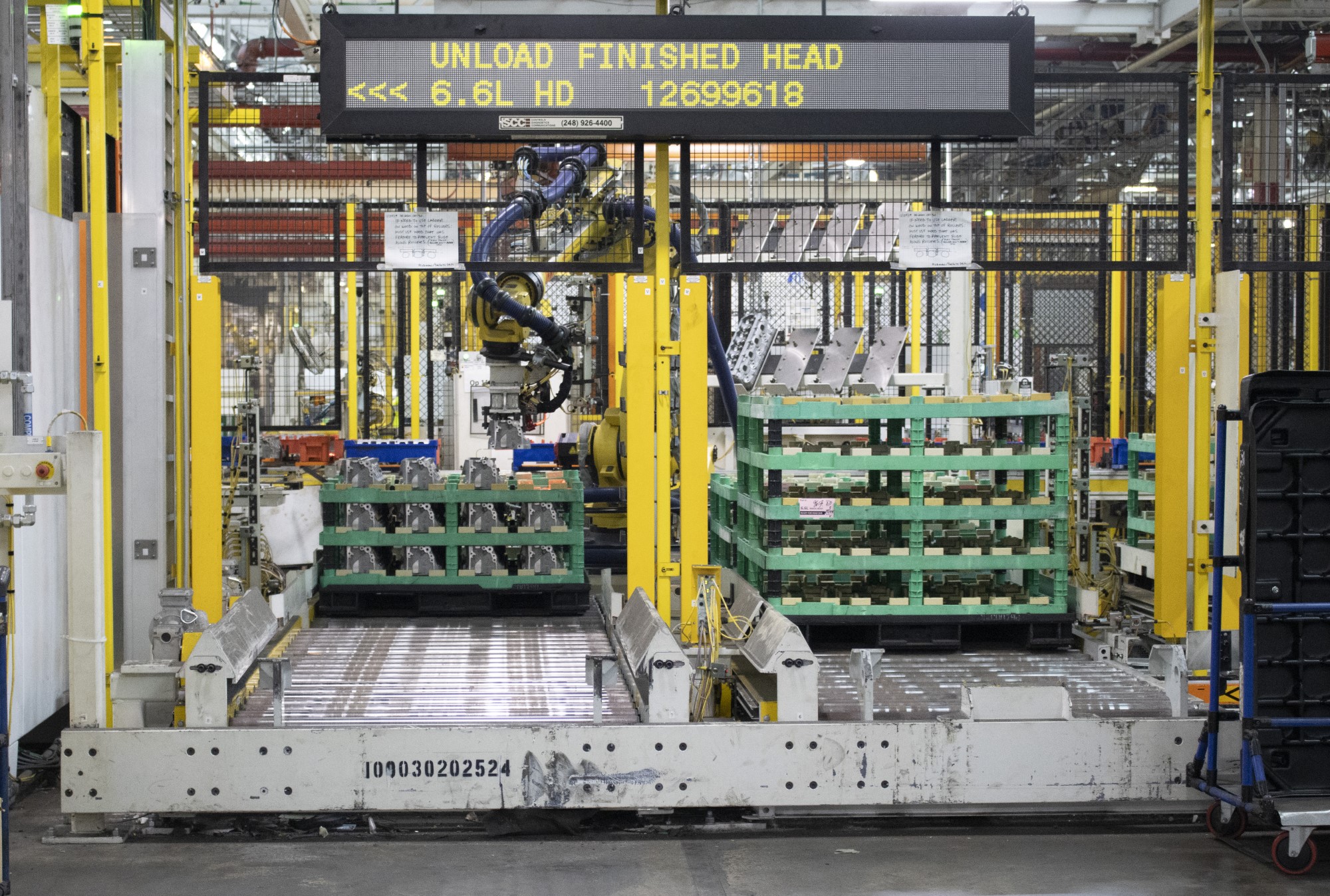 large pallets of completed cylinder heads for 6.6L engine on rollers wait to move to next area for assembly