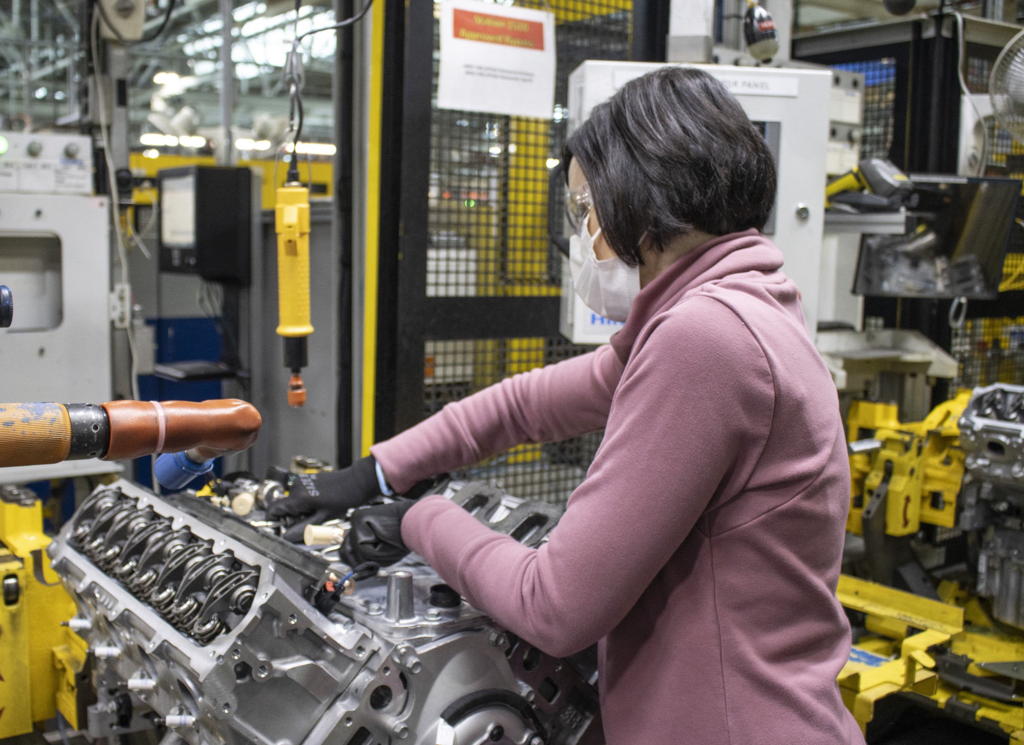 worker tightens parts to engine block