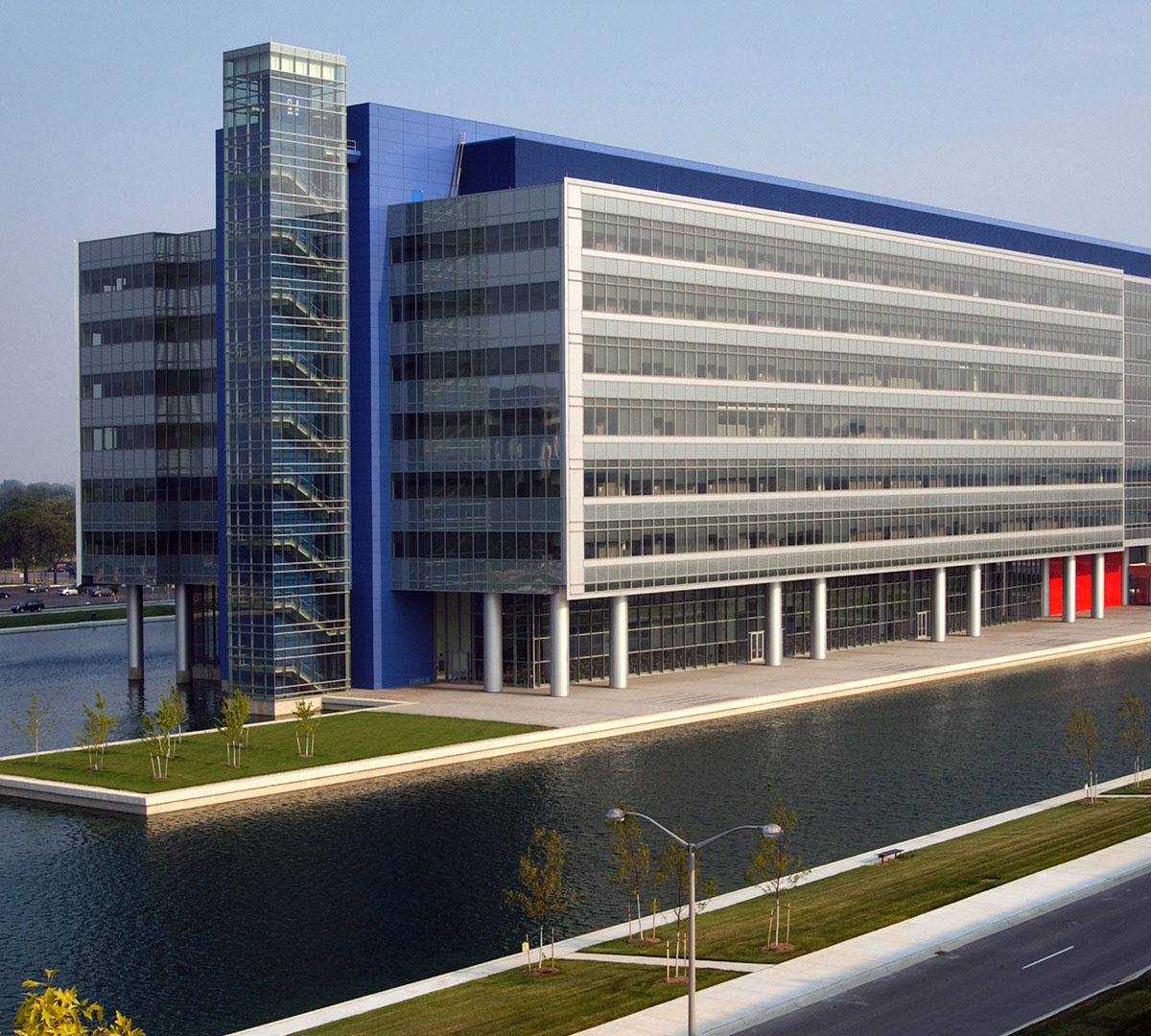Warren Tech Center blue and gray building with many glass windows surrounded by reflecting pools