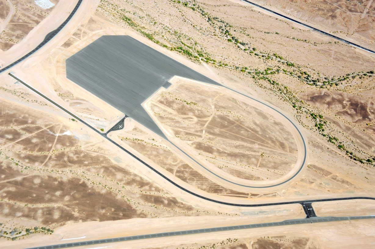 Aerial view of Yuma Desert Proving Grounds Dynamics Pad, a circular loop with large square pad area for vehicle testing.