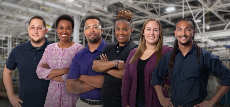 Six GM Manufacturing employees standing side by side