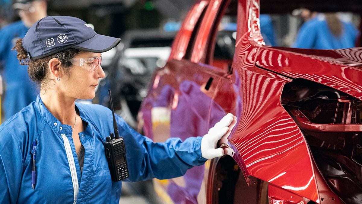 manufacturing A GM Employee Testing the Smoothness of a GM Vehicle Frame's Exterior