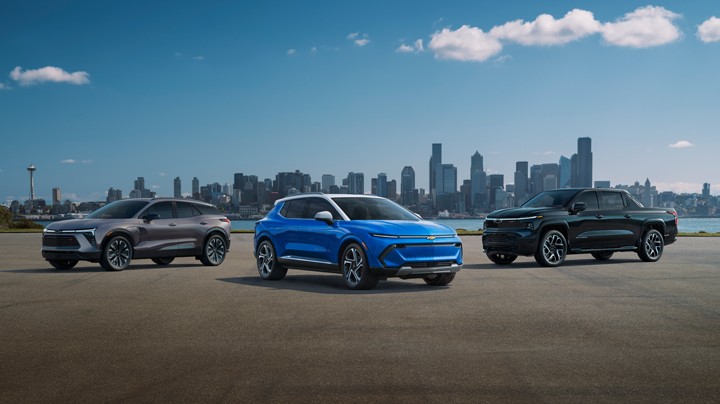 Three Electric Chevrolet Vehicles Parked Next to Each Other Outlooking a City Landscape