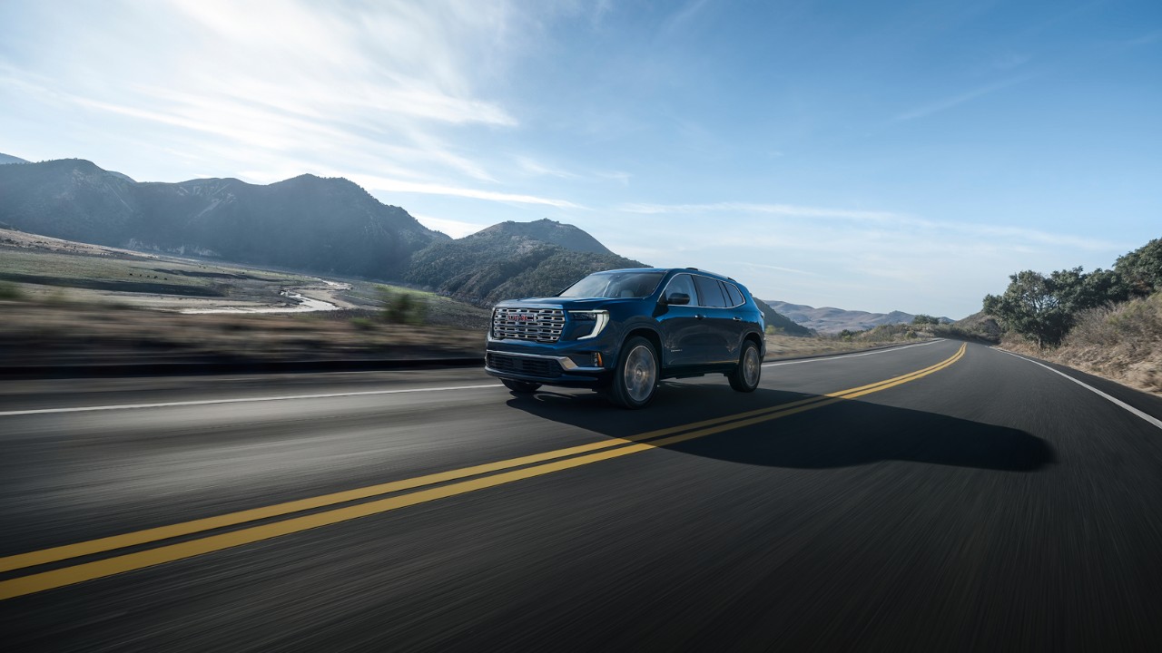 Largest-network Wide Three-quarters View of a GMC Vehicle Driving Down a Road in the Mountains