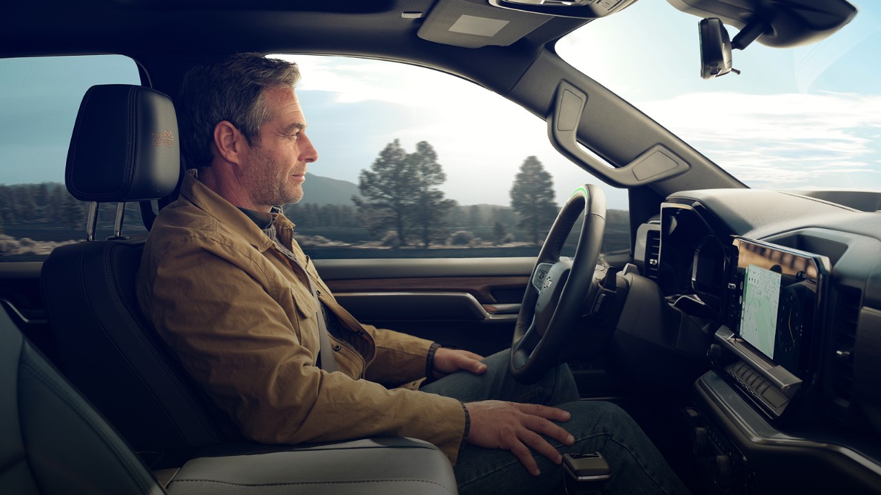 Safety-led Passenger Seat View of a Man Driving a GM Vehicle Utilizing Super Cruise Hands-Free Technology
