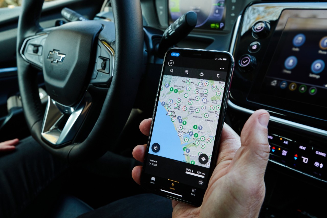 GM introduces Ultium Charge 360, a holistic charging approach that integrates charging networks, GM vehicle mobile apps, and other products and services to simplify the overall charging experience for GM electric vehicle owners. (Photo by Dan MacMedan for Chevrolet) Charging Map on smartphone in Bolt EUV