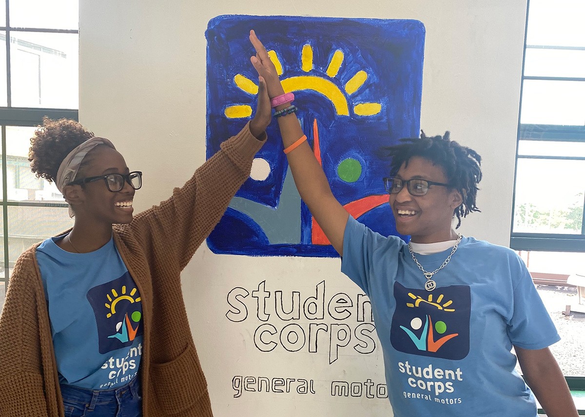East Pointe high school interns painting a GMSC Logo on the wall.